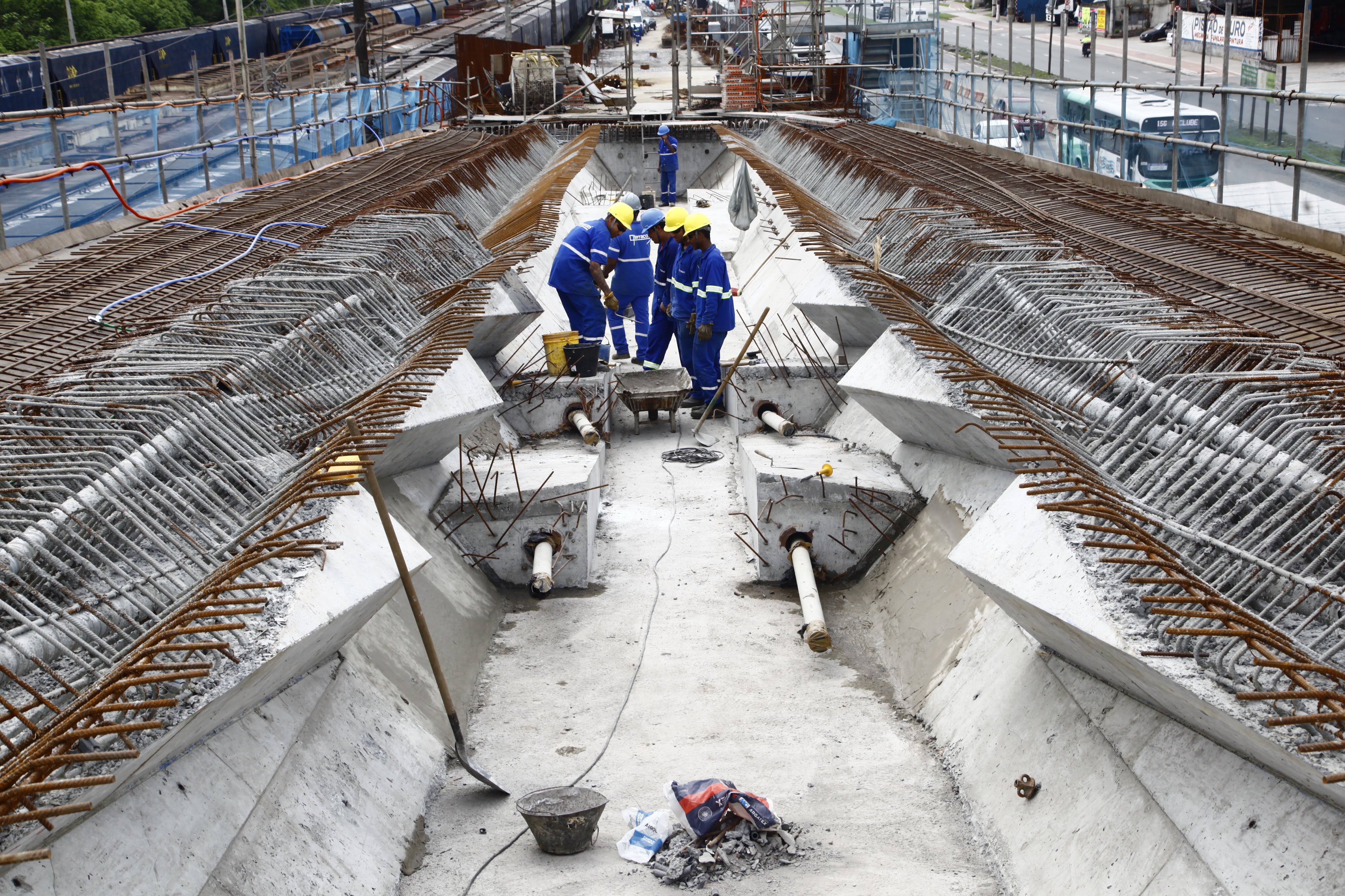 operários reunidos no meio de viaduto em obras #pracegover 