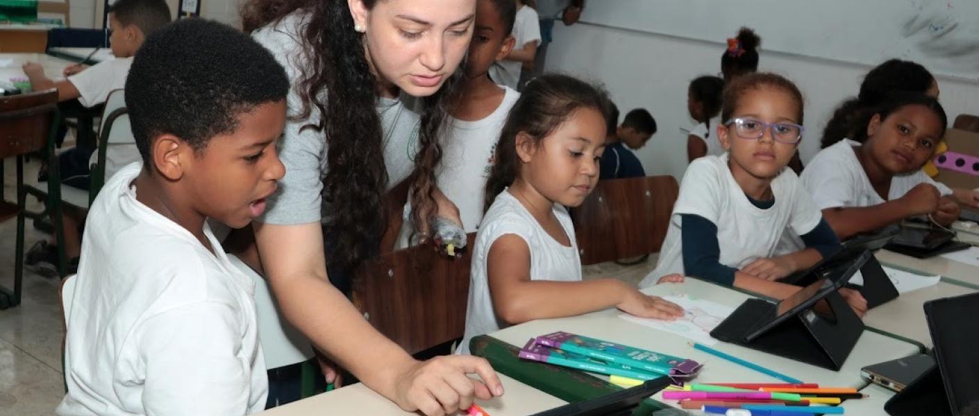 professora mostra tabtlet para aluno #paratodosverem 