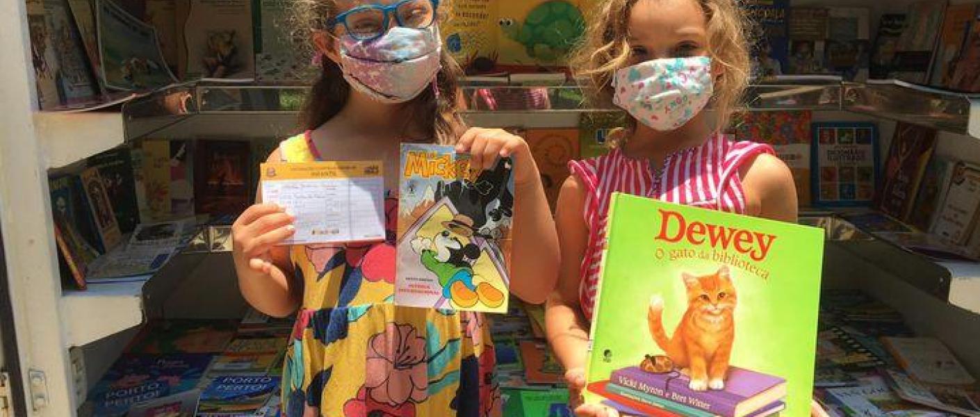 Crianças recebem livros após vacinação contra a covid-19. Meninas mostram livros que ganharam após vacinação contra a covid-19. #pratodosverem