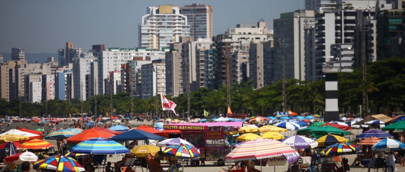 praia cheia com vários guarda-sóis #paratodosverem