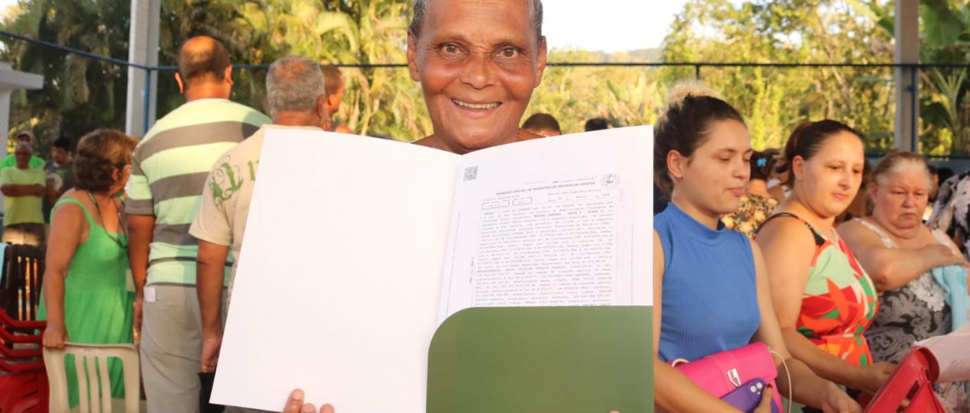 Moradora do Caruara exibe documento: "mudança de vida".