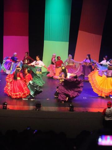 pessoas dançando em palco fantasiadas #paratodosverem