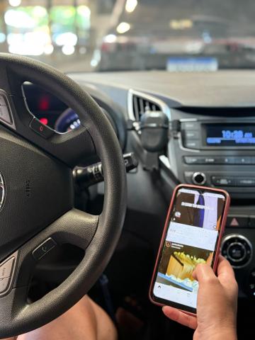 pessoa dirigindo com o celular na mão #paratodosverem