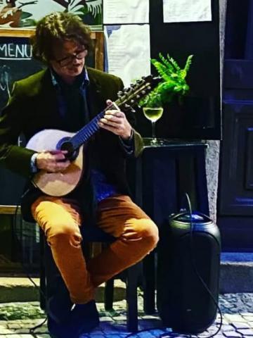 rapaz toca violão em palco #paratodosverem