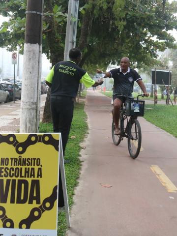 agente entrega panfleso a ciclista #paratodosverem