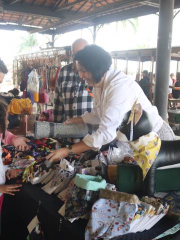 pessoas olhando produtos em feira #paratodosverem