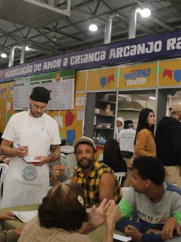 pessoas comendo na festa inverno #paratodosverem
