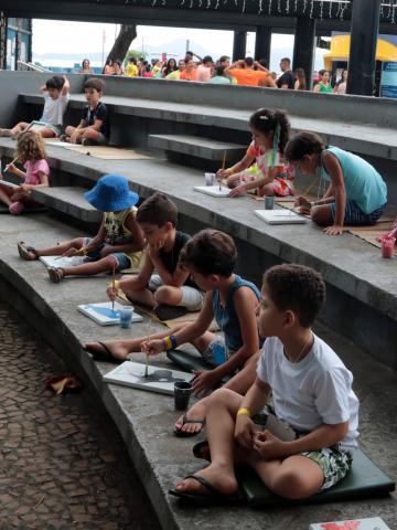 crianças fazem desenhos em área externa do aquário. #paratodosverem