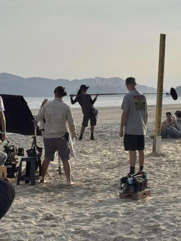 pessoas gravando filme em praia #paratodosverem 