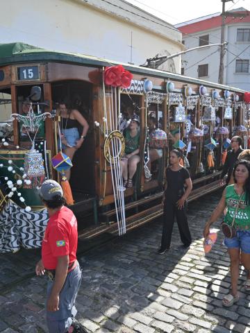 cortejo de foliões junto ao bonde decorado #paratodosverem