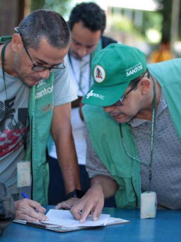 agentes olham papel em mesa #paratodosverem