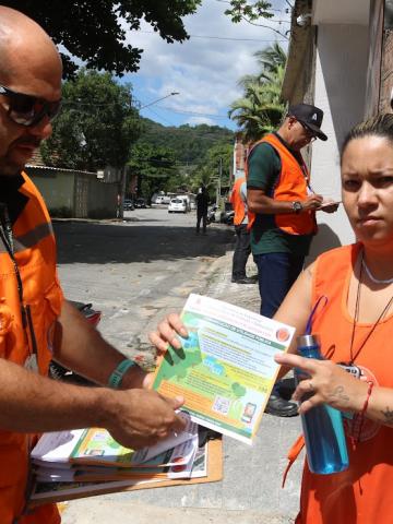 agente da defesa civil entrega panfleto a mulher #paratodosverem