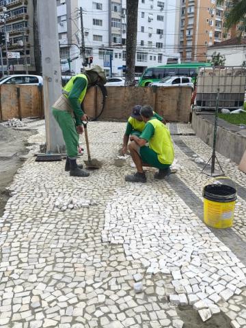 homens trocam piso de praça. #paratodosverem