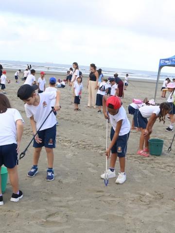alunos coletando lixo na praia #paratodosverem