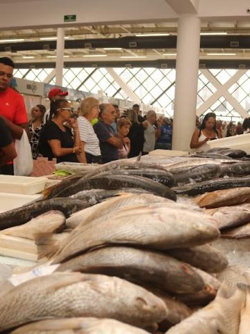 pessoas comprando no mercado de peixes #paratodosverem