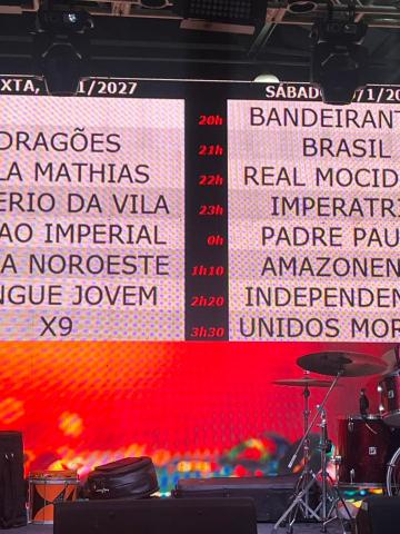 painel com a lista de escolas conforme o dia de desfile. #paratodosverem
