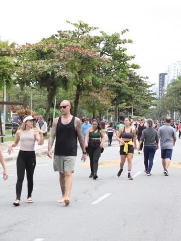 pessoas caminhando na orla #paratodosverem 