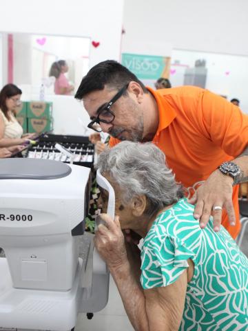 mulher coloca rosto em máquina de exame de vista. #paratodosverem