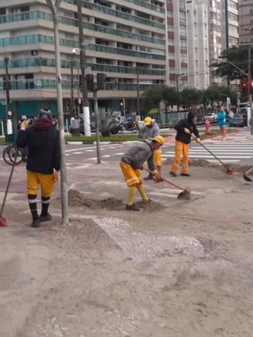 trabalhadores retiram areia de avenida na praia #paratodosverem