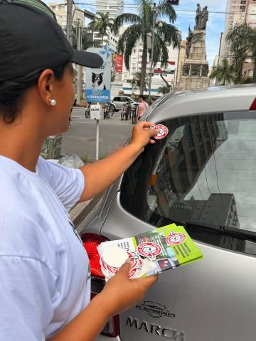 mulher coloca selo em carro #paratodosverem 