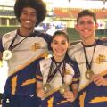tres jovens exibem medalhas #paratodosverem