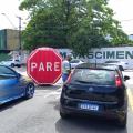 agente da cet está orientando motorista dentro de carro. Na via, à frente, há um grande inflável onde se lê Pare. #paratodosverem