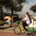 Mulher anda de bicicleta na ciclovia da orla de Santos. #paratodosverem