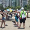 agentes uniformizados abordam mulher que está com cachorro na faixa de areia. #paratodosverem
