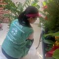 agente uniformizada observa plantas em vasos. #paratodosverem