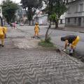 três homens estão capinando meio-fio e calçada. #paratodosverem