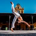 homem faz movimento de capoeira na frente da estação do valongo #paratodosverem 