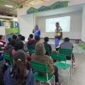 dois homens uniformizados da cet falam a jovens que estão sentados em pátio escolar. #paratodosverem 