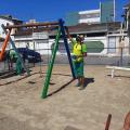 Operários pintam estrutura de balancê em playground. #paratodosverem