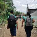 agentes uniformizados caminham por rua de terra. #paratodosverem 