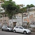 terreno em rua com muro na frente e dois carros parados na via. #paratodosverem