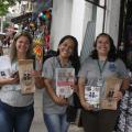 três mulheres mostram panfletos #paratodosverem 