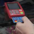 Mão de mulher insere cartão em máquina de crédito/débito - #Pracegover