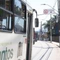 ônibus passa em faixa com placa em cima #paratodosverem 