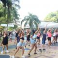 mulheres fazem movimentos iguais de dança em praça. #pratodosverem