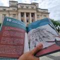 mão segura livro aberto em frente ao paço municipal. #paratodosverem