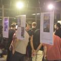 pessoas vendo cartazes da exposição #pracegover