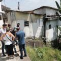 Grupo de pessoas está no alto de uma encosta ao lado de algumas casas. #Paratodosverem