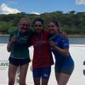 três atletas exibem medalhas com rio ao fundo #paratodosverem