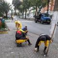 homens uniformizados raspam trecho de calçada. #paratodosverem