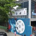 fachada do equipamento com grafite de pelé dando o soco no ar e uma grande bola de futebol ao fundo. #paratodosverem 
