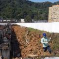Homem trabalha em obra próximo a parede do cemitério. #paratodosverem