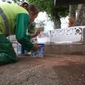 operária pintando guia em cemitério #paratodosverem