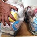 mão segura pacote com alimentos não perecíveis. #paratodosverem