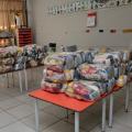 cestas básicas empacotadas estão dispostas sobre três longas mesas.#paratodosverem