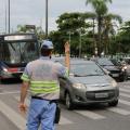 Agente está na pista, próximo a uma faixa de segurança. Ele sinalizada para carros em movimento. #Paratodosverem